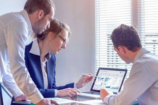 Equipe de funcionários de agência de marketing médico analisando dados no computador