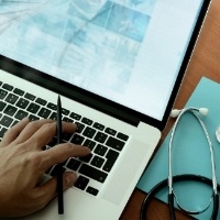 top view of Medicine doctor hand working with modern computer and smart phone on wooden desk as medical concept-632184-edited-925989-edited