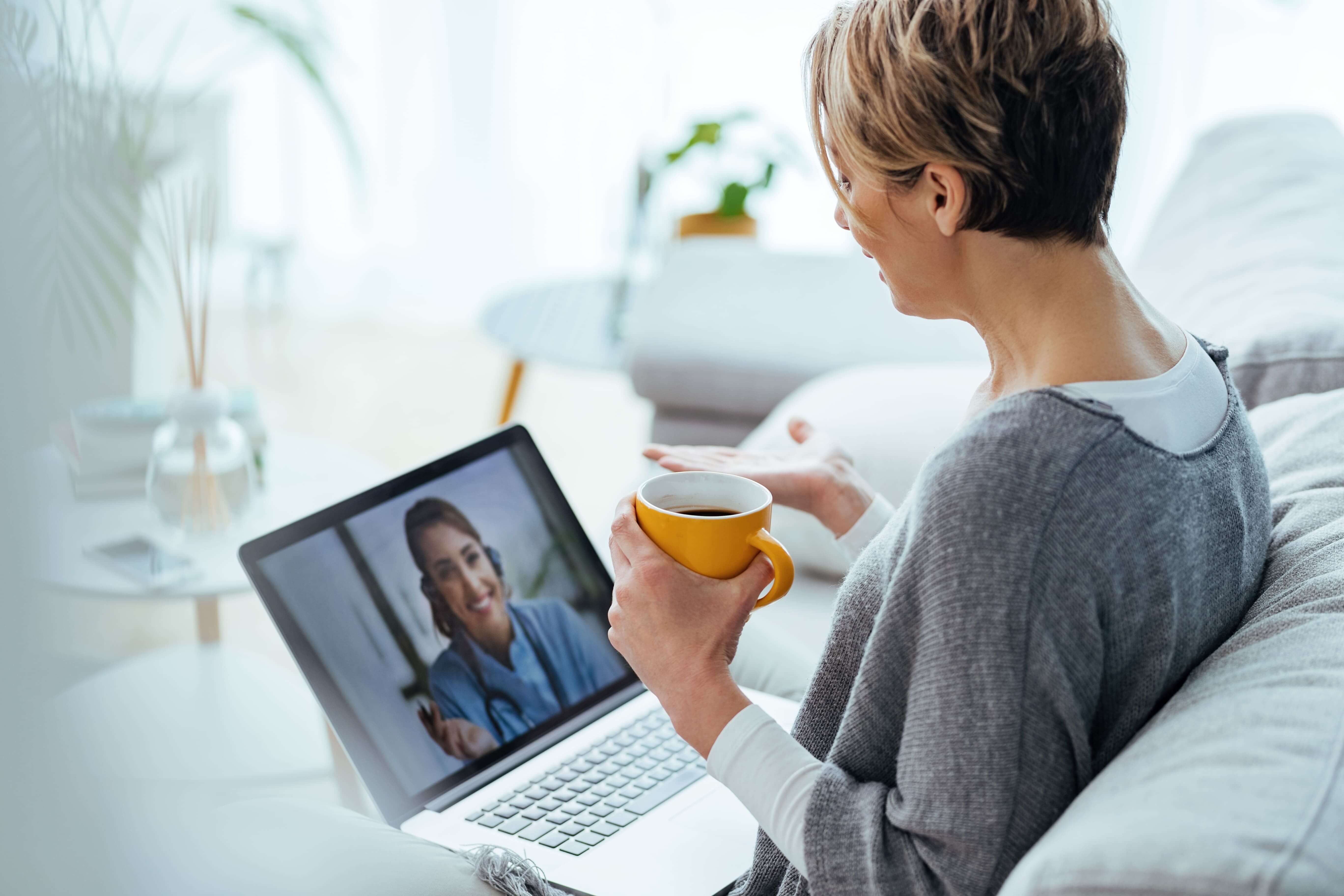 Woman-using-laptop-and-having-video-call-with-her-doctor-while-sitting-at-home.-1216972964_5472x3648